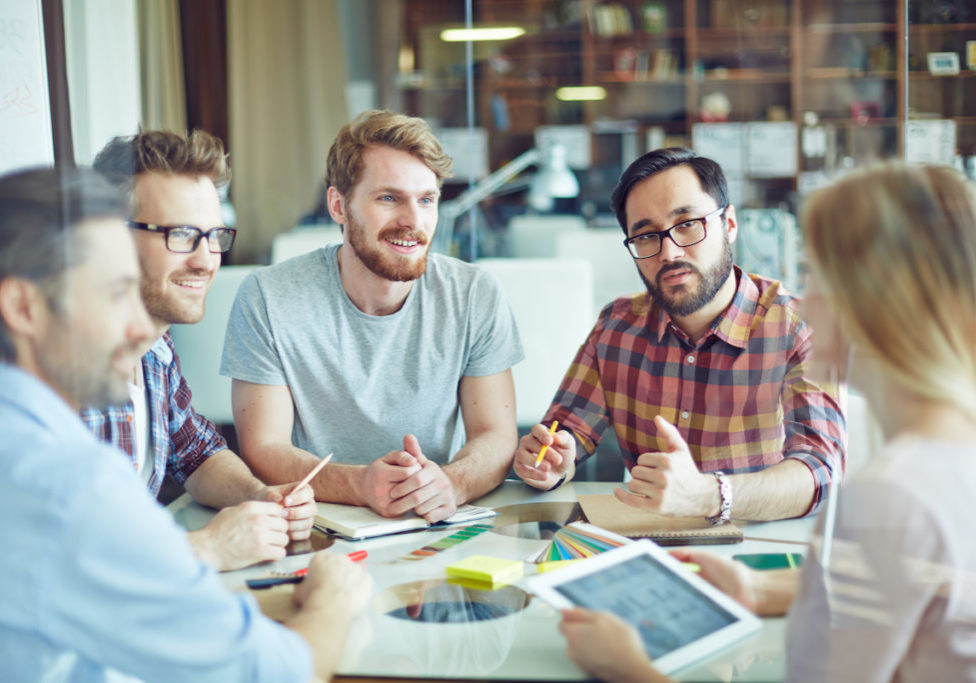 Group of confident managers listening to female employee